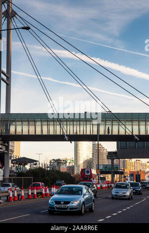 London, England, Regno Unito - 10 dicembre 2011: Flussi di traffico lungo la West India Dock Road sotto la passerella di legno di pioppo DLR station nei Docklands di riconvertire Foto Stock