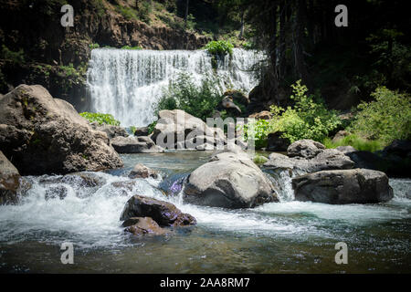 Rocky creek con ampia cascata bassa in background Foto Stock