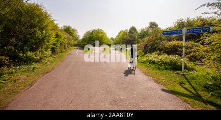 Bristol, Inghilterra, Regno Unito - 21 Aprile 2011: I ciclisti ride passato le vecchie piattaforme della stazione Mangotsfield sul Bristol e Bath percorso ferroviario. Foto Stock