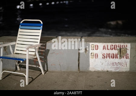 Sedia spiaggia su calcestruzzo boardwalk di notte Foto Stock