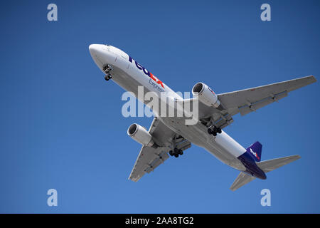 Piano di FedEx a volare su un giorno chiaro con un luminoso cielo blu Foto Stock