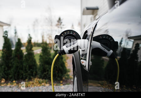 Auto elettrica filo inserito in una macchina elettrica a casa Foto Stock