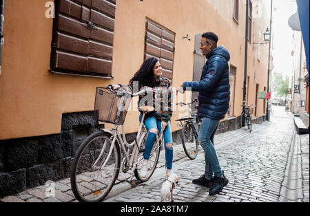 L uomo e la donna per le strade in Europa sat parlando su un push bike Foto Stock