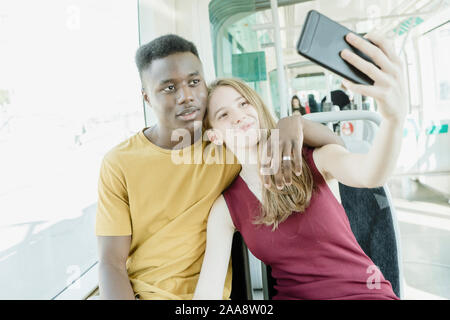 Un ragazzo e una ragazza in amore prendendo un selfie sul bus Foto Stock