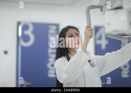 Asia donna medico dispositivo di controllo in un ospedale Foto Stock