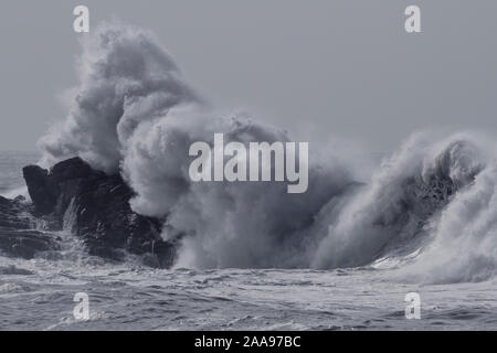 Mare mosso schizzi d'onda. Portoghese settentrionale costa rocciosa. Nei toni del blu. Foto Stock