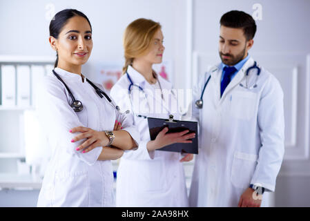 Attraente femmina medico arabo nella parte anteriore del materiale medico Foto Stock