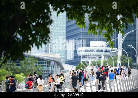 (Fuoco selettivo) folla di persone locali e turisti a piedi su un ponte in Singapore. Foto Stock