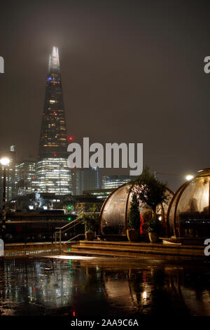 Le cialde da pranzo presso la Coppa club il Tower Bridge di Londra e il coccio su un umido di notte. Foto Stock