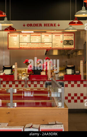 Server che operano all'interno di un cinque ragazzi ristorante un ristorante fast food Foto Stock