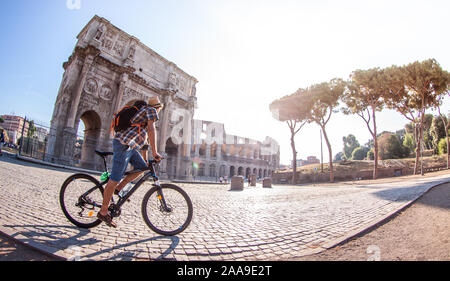 Felice giovane turista con moto indossando maglietta e cappello all arco di Costantino vicino al Colosseo a Roma, Italia di sunrise. Foto Stock