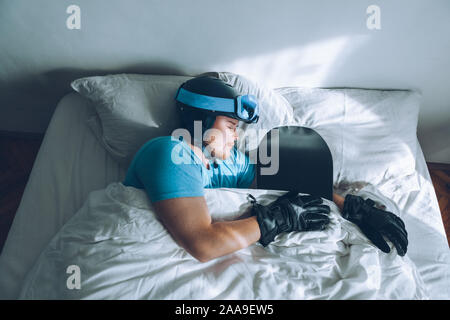 Uomo nel letto con lo snowboard ski googles e casco Foto Stock