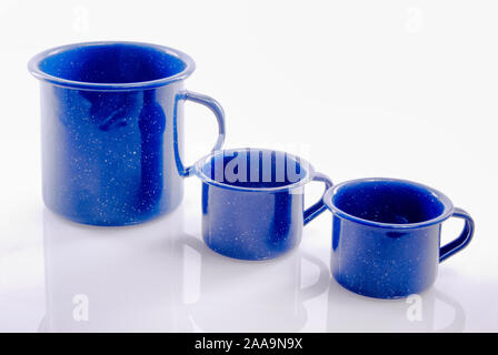 Set di tre pulire blu scuro stagno vuoto tazze da caffè su un sfondo riflettente. Foto Stock