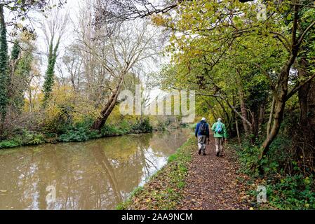 Il fiume Wey navigazione a Byfleet con due escursionisti sulla strada alzaia in un colorato autunno il giorno Surrey in Inghilterra REGNO UNITO Foto Stock