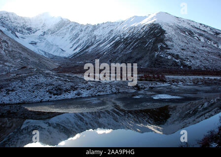 Un piccolo ghiacciaio è riflessa nelle acque di un lago di montagna nelle montagne Daxueshan del Sichuan Foto Stock