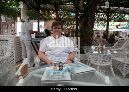 Una donna si siede ad un tavolo all'Arabian Tea House Restaurant & Cafe - Al Fahidi Foto Stock