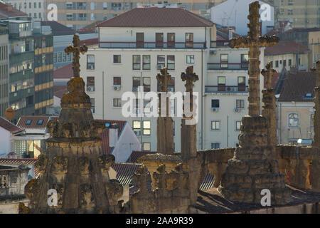 Croci in pietra sulla chiesa di Santa Cruz con edifici moderni in background in Coimbra Portogallo Foto Stock