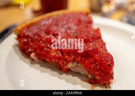 Close-up di Chicago-style deep dish pizza slice sulla piastra bianca, 4 novembre 2019. () Foto Stock