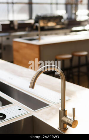 Miscelatore acqua rubinetto e lavello in cucina moderna con interni. Foto Stock