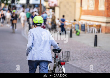 Ciclista sulla strada di Cambridge per una intensa giornata di sole di fronte il Kings College Foto Stock