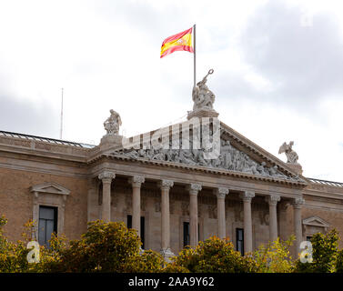 Spanish flag sventolare sopra il portico della Biblioteca Nazionale di Madrid Foto Stock