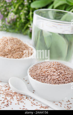 Crusca di frumento e Indianwheat con un bicchiere di acqua Foto Stock