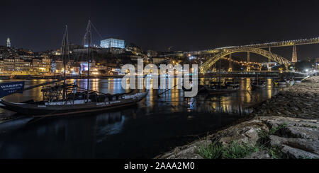 Rabelo barche tradizionali per il trasporto dei vini sul fiume Douro, Porto, con il Dom Luís I Bridge in background. Foto Stock