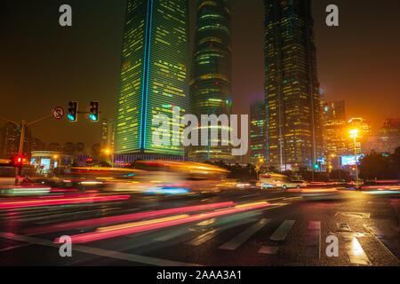 Sentieri di luce sull'edificio moderno background in Cina a Shanghai. Splendidi grattacieli di misty cielo notturno delle principali città asiatiche. Foto Stock