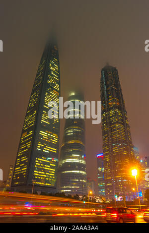 Sentieri di luce sull'edificio moderno background in Cina a Shanghai. Splendidi grattacieli di misty cielo notturno delle principali città asiatiche. Foto Stock