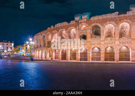 Verona, Italia. Antico anfiteatro Arena di Verona in Italia come Roma Colosseo con illuminazione notturna e la sera cielo blu. Verona italiano della fam Foto Stock