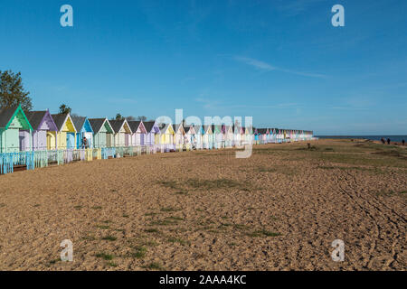 Una fila di color pastello spiaggia capanne a West Mersea. Mersea Island, Essex, Regno Unito. Foto Stock