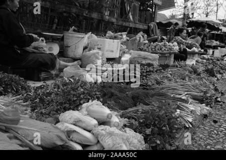 Laos: una donna vendita di ortaggi freschi sul mercato a Luang Brabang Foto Stock