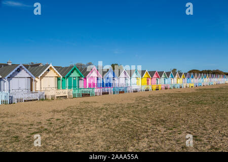 Una fila di color pastello spiaggia capanne a West Mersea. Mersea Island, Essex, Regno Unito. Foto Stock