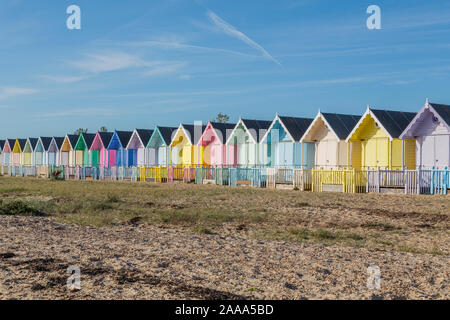 Una fila di color pastello spiaggia capanne a West Mersea. Mersea Island, Essex, Regno Unito. Foto Stock