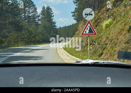 Segno per una frana su una strada attraverso un paesaggio di campagna in primavera Foto Stock