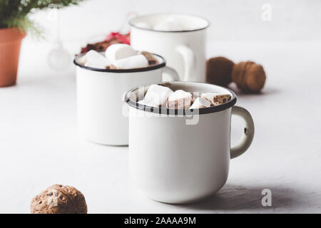 Hot Chocolate, Cocoa sulla festosa tavolo bianco, tradizionale autunno e inverno bevanda calda con marshmallow in bianco tazze, close up Foto Stock