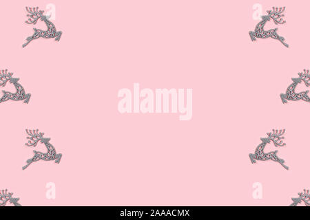 Modello realizzato di bianco Natale cervi decorazione sul rosa pastello sfondo. Concetto di natale. Foto Stock