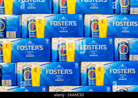 Scatole impilate contenente lattine di Foster's lager per la vendita in un supermercato. Foto Stock