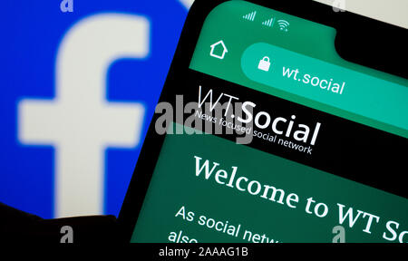 WT.Sito web sociale sullo smartphone e logo di Facebook sullo sfondo. Peso:sociale è focalizzato notizie social network forma fondatore di Wikipedia. Foto Stock
