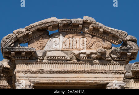 Chiusura del fregio scolpito con una faccia e fiori sulla biblioteca di Celso a Efeso in Turchia. Foto Stock