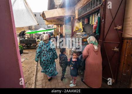 Fez, in Marocco. Il 9 novembre 2019. donne e bambini tra i negozi e bancarelle di frutta e verdura nel centro della città Foto Stock