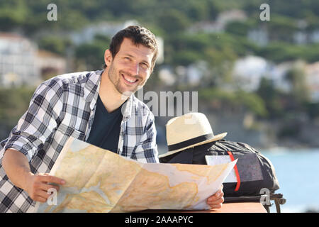 Felice azienda turistica mappa guarda la fotocamera in una città costiera su vacanze estive Foto Stock