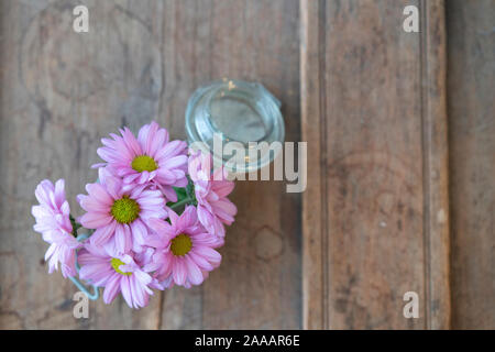 Fiori estivi dal di sopra in un vaso di vetro su un vile in legno elemento rustico Foto Stock