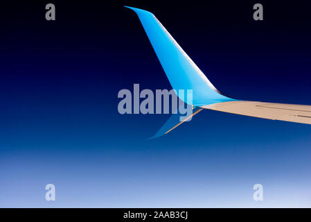 Ala di aeroplano. Blu punta ala del velivolo contro il cielo scuro. Foto Stock
