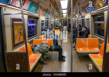 New York, Stati Uniti d'America, 9 novembre 2019. Passeggeri ignorare un povero uomo dorme nella metropolitana di New York City. Credito: Enrique Shore/Alamy Stock Photo Foto Stock