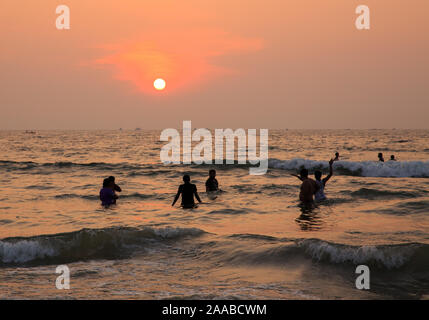 Un gruppo di persone godersi il tramonto a Malpe beach (Karnataka, India) Foto Stock