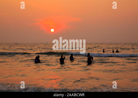 Un gruppo di persone godersi il tramonto a Malpe beach (Karnataka, India) Foto Stock