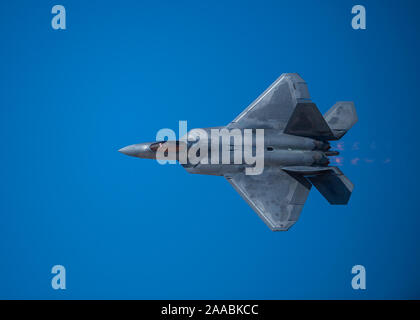 Un F-22 Raptor Fighter jet assegnati alle armi 433rd Squadron pops flares durante la nazione di aviazione 2019 air show alla Nellis Air Force Base in Nevada, nov. 16, 2019. La F-22 ha risposto ad una simulazione di aria-terra di attacco da parte di due F-16 Fighting Falcon jet fighter assegnato al sessantaquattresimo aggressori Squadron durante i bracci combinato di dimostrazione. (U.S. Air Force foto di Airman 1. Classe Bryan Guthrie) Foto Stock