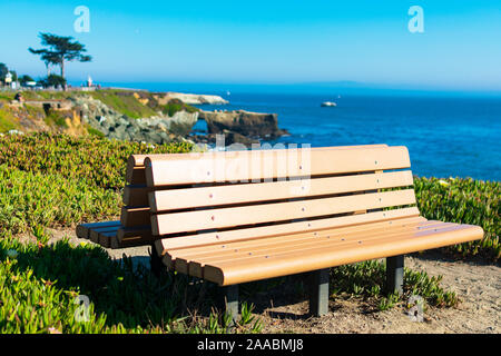 Banco costiere con un incredibile vista dell'Oceano Pacifico costa scogliere e sfocata faro Foto Stock