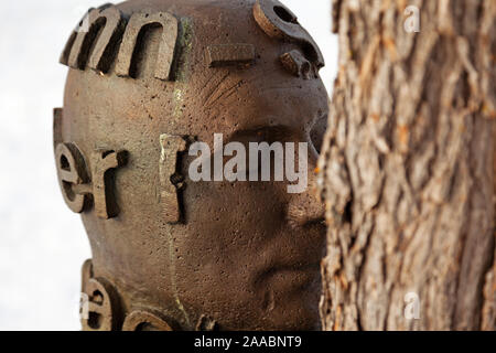 Umea, Norrland Svezia - 22 Ottobre 2019: close-up artwork dove statua abbracci alberi a Umedalen Foto Stock